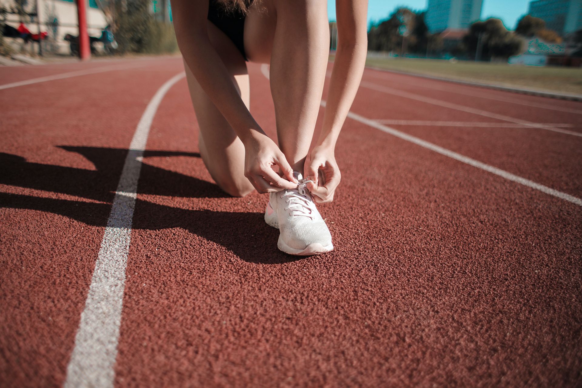 Eine Frau bindet sich die Schuhe und macht sich bereit für die kommende Challenge.