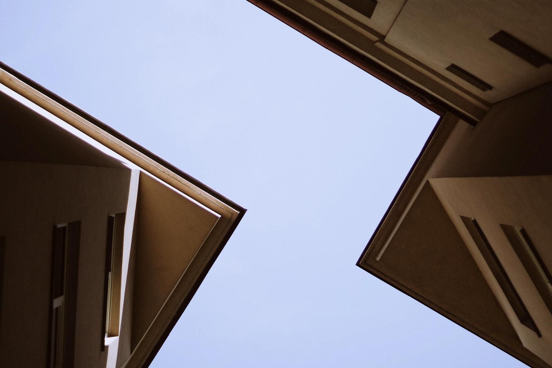 Ein Ausschnitt zweier Dächer von unten Fotografiert, Richtung Himmel.
