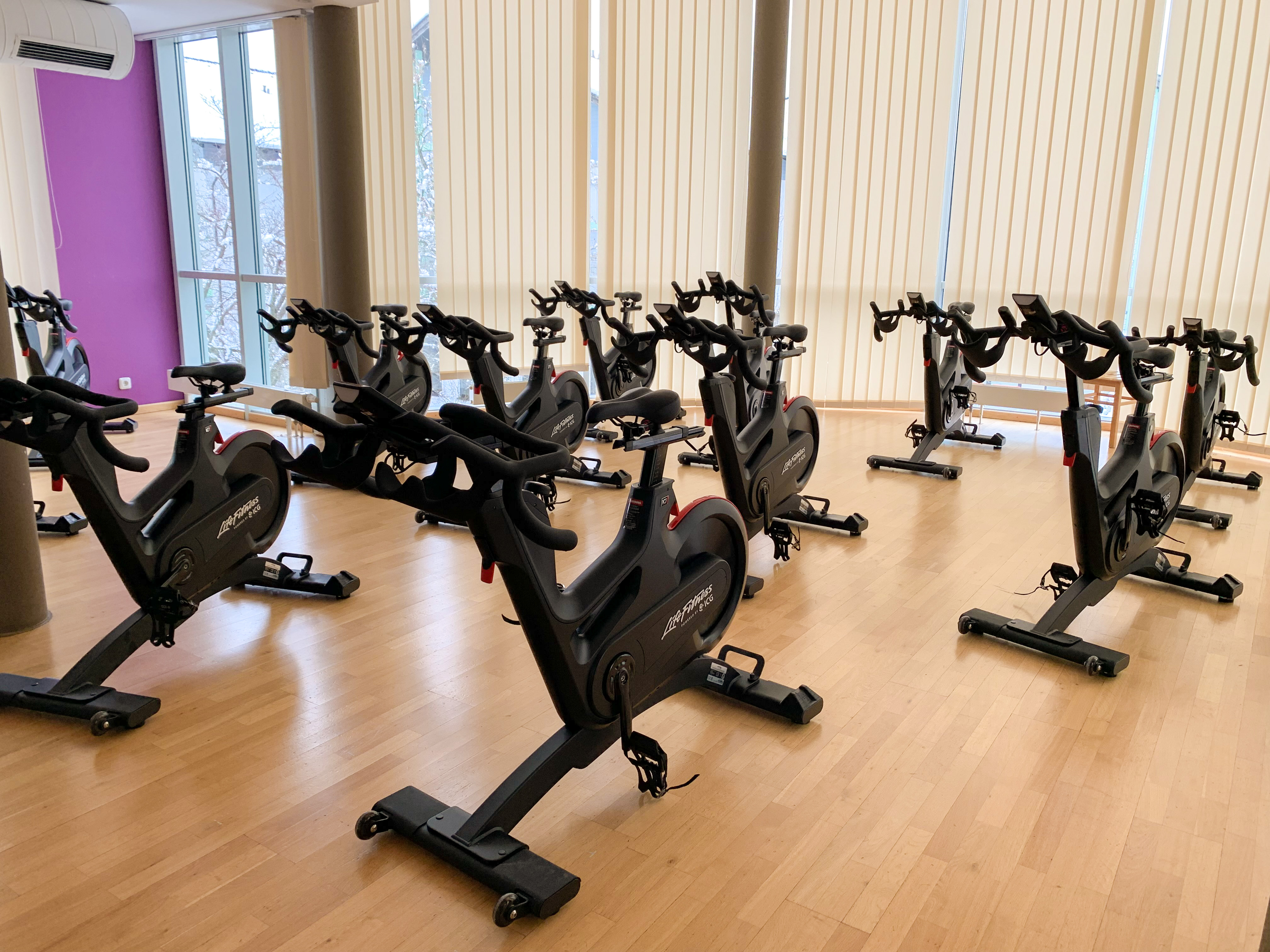 Motivierende Atmosphäre im Kursraum voller topmoderner Indoor Cycling Bikes.