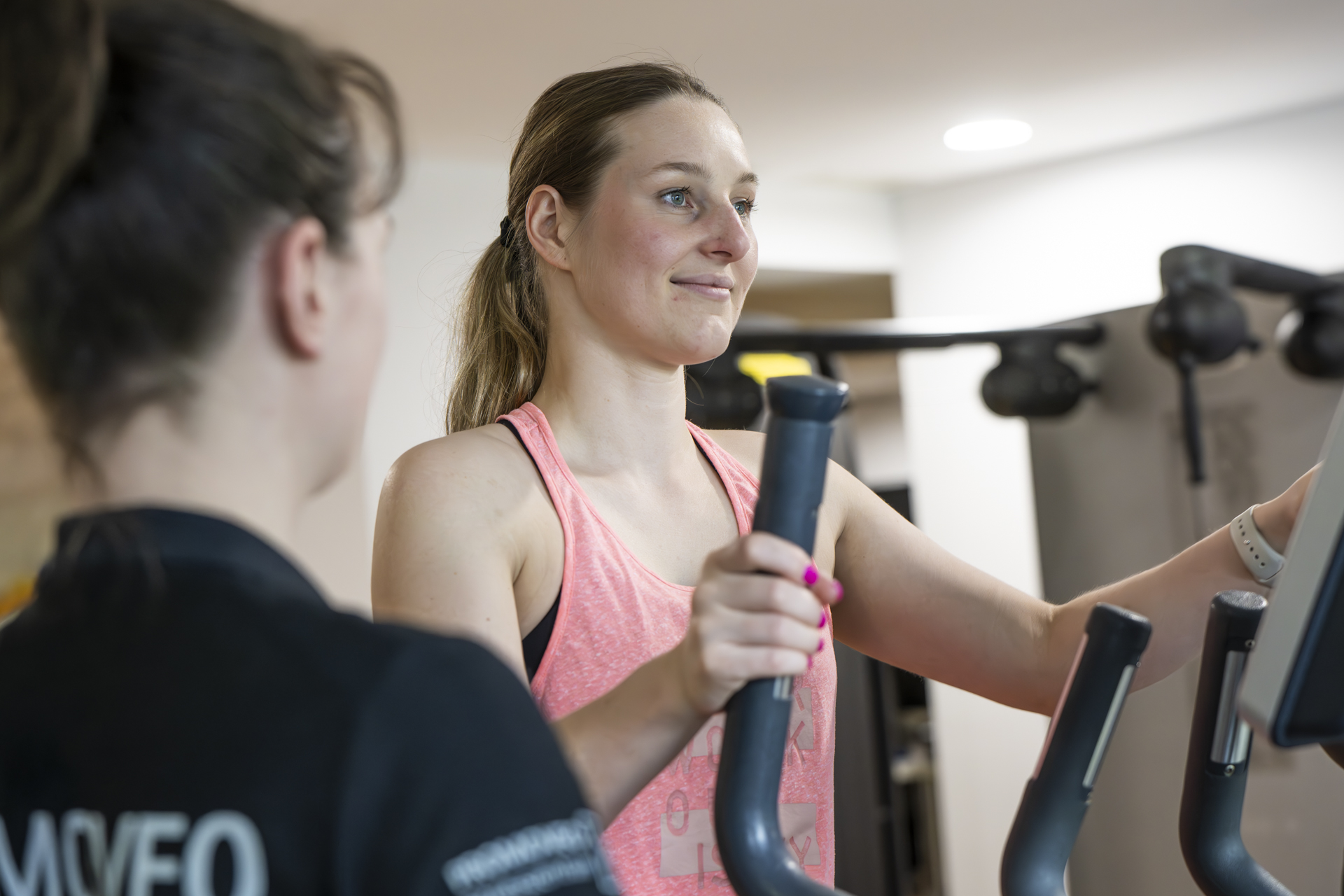 Eine Trainerin erklärt die richtige Ausführung einer Übung im PROMOVEO Fitnesszentrum